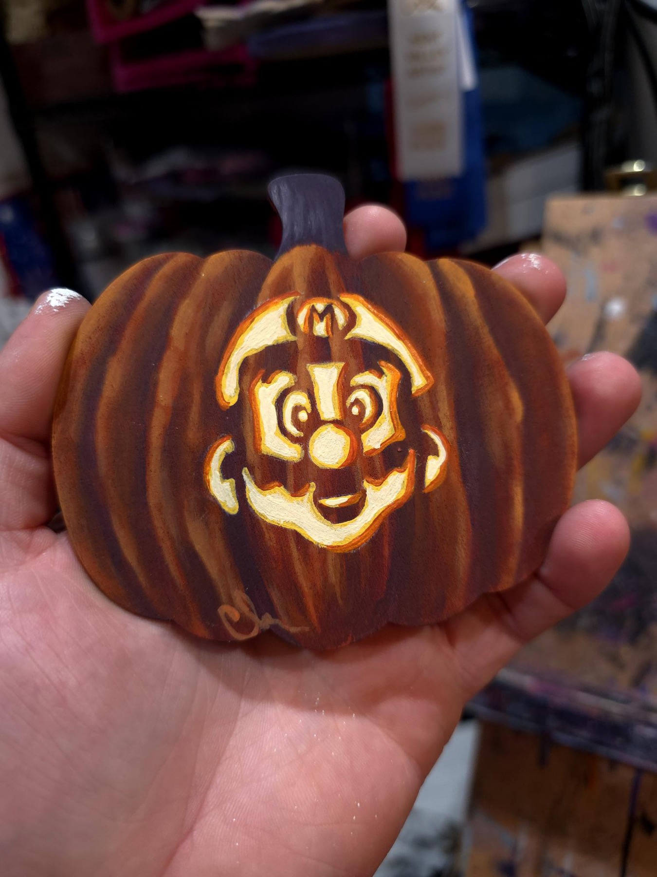 Small carved pumpkin with glowing Mario character face